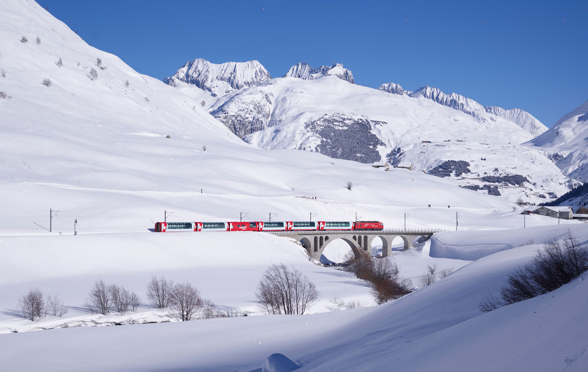 Glacier Express rolling past ski resorts in winter